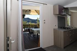 a kitchen with a wooden deck with a table and a dining room at Camping Mare Monti in Sestri Levante