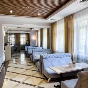 a waiting room with blue couches and tables at Golden Palace Hotel in Almaty