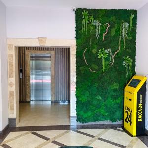 una pared verde en un pasillo con una caja amarilla en Golden Palace Hotel, en Almaty
