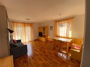 a living room with a couch and a table and chairs at Amalia Apartment in Santa Cristina Gherdëina