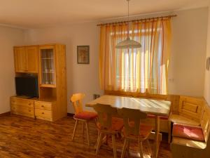 - une cuisine et une salle à manger avec une table et des chaises dans l'établissement Amalia Apartment, à Santa Cristina Valgardena