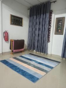 Rizqy Homestay di Jitra في جيترا: غرفة بها سجادة زرقاء وبيضاء على الأرض