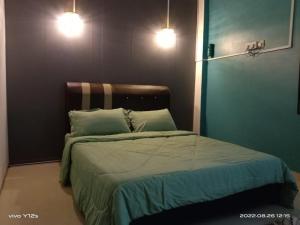 - une chambre avec un lit avec deux oreillers et deux lumières dans l'établissement Rizqy Homestay di Jitra, à Jitra