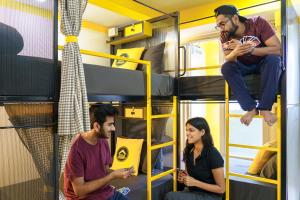a group of three people sitting in a bunk bed at The Hosteller Dehradun in Dehradun
