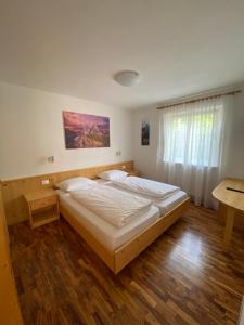 - une chambre avec 2 lits, une table et une fenêtre dans l'établissement Amalia Apartment, à Santa Cristina Valgardena