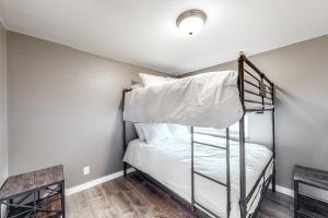 a bedroom with a bunk bed with white sheets at Idahome in Athol