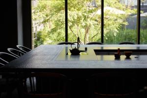 a dining room table with chairs and a large window at THE HOTEL HIGASHIYAMA by Kyoto Tokyu Hotel in Kyoto