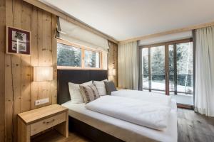 a bedroom with a large bed and a window at Chalet Martina Apartments in San Vigilio Di Marebbe