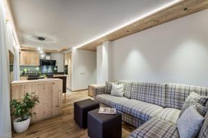 a living room with a couch and a kitchen at Chalet Martina Apartments in San Vigilio Di Marebbe