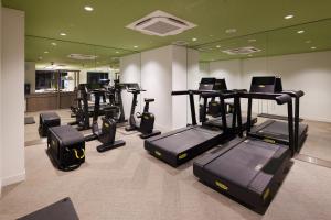 a gym with a row of treadmills and machines at THE HOTEL HIGASHIYAMA by Kyoto Tokyu Hotel in Kyoto