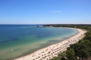 eine Luftansicht auf einen Strand mit Menschen und Sonnenschirmen in der Unterkunft Grand Hotel Seeschlösschen Sea Retreat & SPA in Timmendorfer Strand