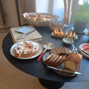 a table filled with different types of bread and pastries at Au Ralenti du Lierre in Beaumettes