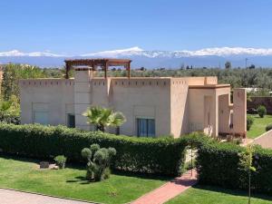 a large house with bushes in front of it at Villa Selma avec piscine chauffée in Marrakesh