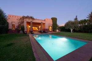 a swimming pool in front of a house at Villa Selma avec piscine chauffée in Marrakesh