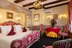 a hotel room with two beds and a table at Hotel Restaurant Le Maréchal - Les Collectionneurs in Colmar