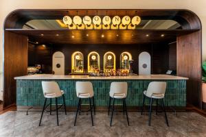 a bar with white stools in front of it at Barceló Tenerife in San Miguel de Abona +151 photos