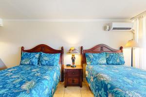 1 dormitorio con 2 camas y mesa con lámpara en Islander on the Beach 370, en Kapaa