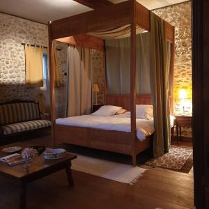 - une chambre avec un lit à baldaquin et une table dans l'établissement Les Logis de Lestiac, à Lestiac-sur-Garonne