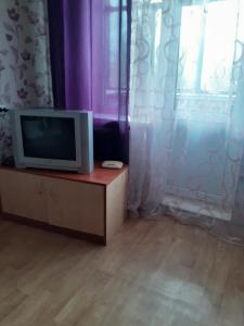 a tv sitting on a dresser next to a window at Чорних Запорожців 17, інститут серця in Kyiv