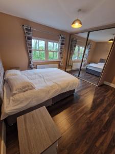 a bedroom with a large bed and a mirror at Mountmahon House in Abbeyfeale