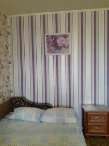 um quarto com uma cama com uma parede listrada em Чорних Запорожців 17, інститут серця em Kiev