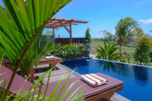 a swimming pool with a table and chairs next to a resort at Gama’s Villa in Tabanan