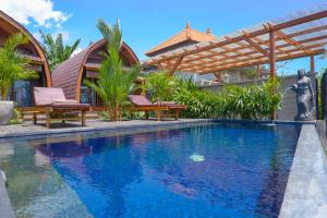 a swimming pool in a house with a wooden pergola at Gama’s Villa in Tabanan
