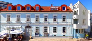 duży biały budynek z czerwonym dachem w obiekcie Appartements Donaublick w Linzu