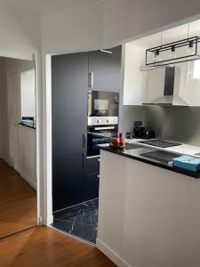 cocina grande con encimera en blanco y negro en Neuilly-Sur-Seine : 2 pièces 40 m2- central en Neuilly-sur-Seine