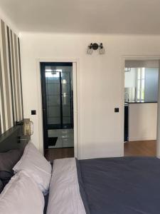 1 dormitorio con cama y espejo grande en Neuilly-Sur-Seine : 2 pièces 40 m2- central en Neuilly-sur-Seine