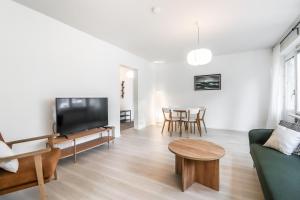 ein Wohnzimmer mit einem Sofa und einem Tisch in der Unterkunft Cosy flat with good transport connections in Vantaa