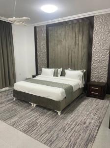 - une chambre avec un grand lit et des oreillers blancs dans l'établissement Al Aryam Villa, à Mawāliḩ