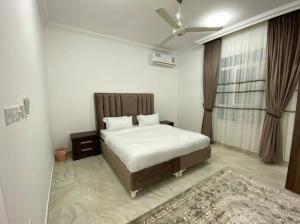 1 dormitorio con 1 cama y ventilador de techo en Al Aryam Villa, en Mawāliḩ