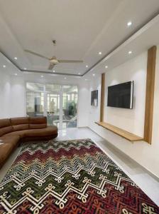 Al Aryam Villa في Mawāliḩ: غرفة معيشة مع أريكة وتلفزيون بشاشة مسطحة
