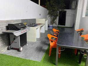 a kitchen with a grill and a table and chairs at Al Aryam Villa in Mawāliḩ