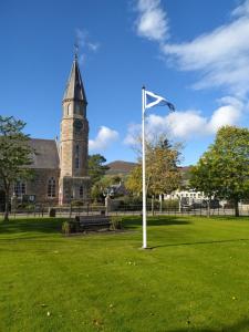 a flag in front of a building with a church at Lottie’s Cottage, Rhynie, Aberdeenshire in Rhynie