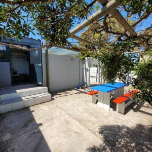 einem Picknicktisch und Bänken außerhalb eines Hauses in der Unterkunft Shell Cottage a stone's throw from the beach in Langebaan + 4 Fotos