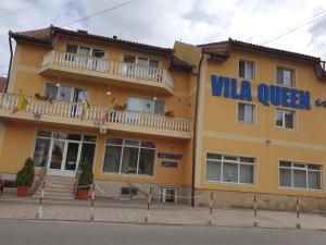 un edificio amarillo con un letrero que lee Villa Queen en Vila Queen en Arad