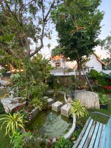 um jardim com um lago em frente a uma casa em Sherloft Home & Hostel em Chiang Mai