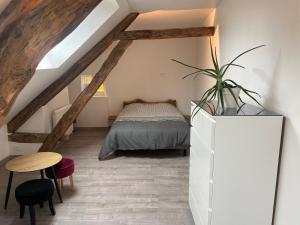 een slaapkamer op zolder met een bed en een tafel bij Wine house in Chablis