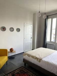 - une chambre avec un lit et une chaise jaune dans l'établissement Le triomphe logement central, 8 pax 3 chambres, à Marseille