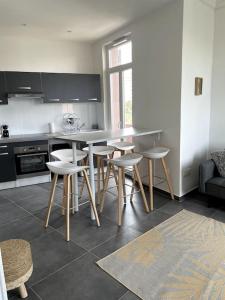 - une cuisine avec une table et des tabourets dans une pièce dans l'établissement Le triomphe logement central, 8 pax 3 chambres, à Marseille