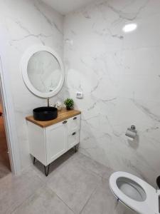 een badkamer met een wastafel, een spiegel en een toilet bij זריחה למרגלות הגלבוע in Nurit