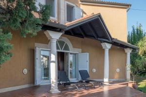 een huis met twee stoelen op een patio bij Villa Alberi with pool in Savudrija