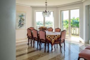 een eetkamer met een tafel en stoelen bij Villa Alberi with pool in Savudrija