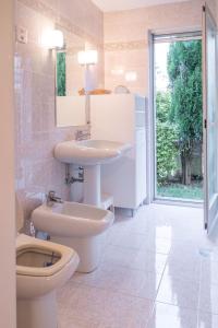 een badkamer met een toilet, een wastafel en een toilet bij Villa Alberi with pool in Savudrija