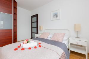 a bedroom with a bed with roses on it at Spacious Apartment Pałac Jana III Wilanów by Renters in Warsaw