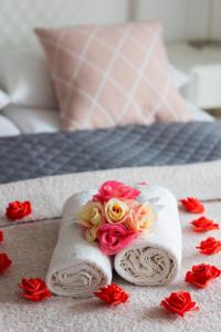a pair of towels with flowers on a bed at Spacious Apartment Pałac Jana III Wilanów by Renters in Warsaw