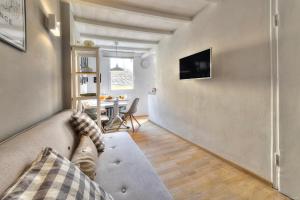 a living room with a couch and a television at Santo Spirito Romantic by Mmega in Florence