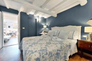a bedroom with a large bed with blue walls at Santo Spirito Romantic by Mmega in Florence